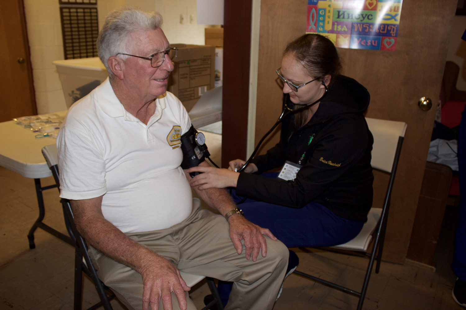 Woman takes the blood pressure of an older man