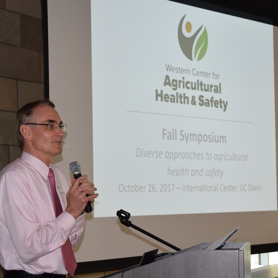 Dr. Kent Pinkerton gives opening remarks standing next to projection screen