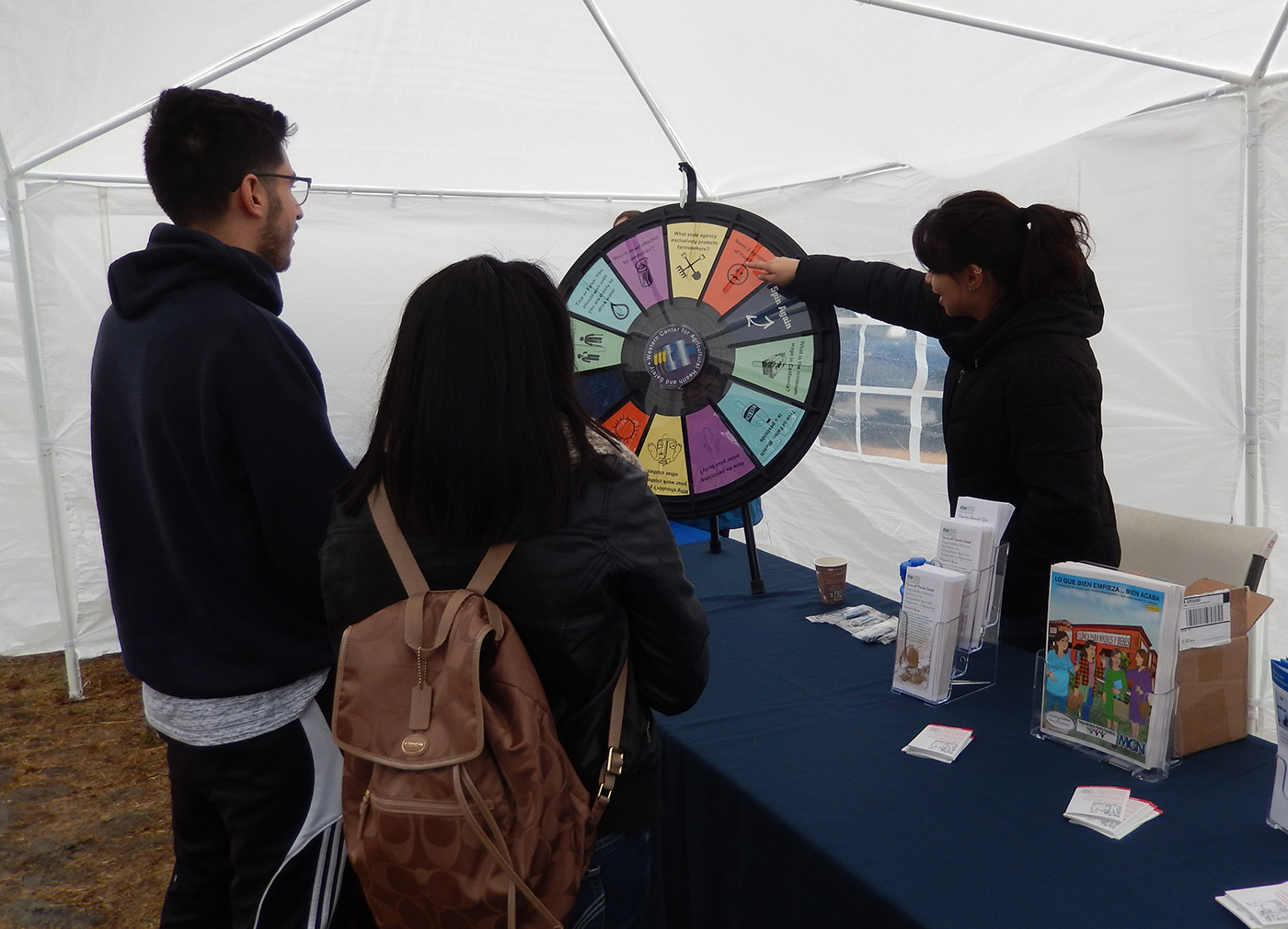 Outreach staff member, Leslie Olivares, interacts with members of the community at the WCAHS booth