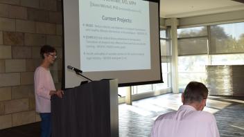Dr. Diane Mitchell stands at podium in front of screen showing slides of CHIPS 2 research 