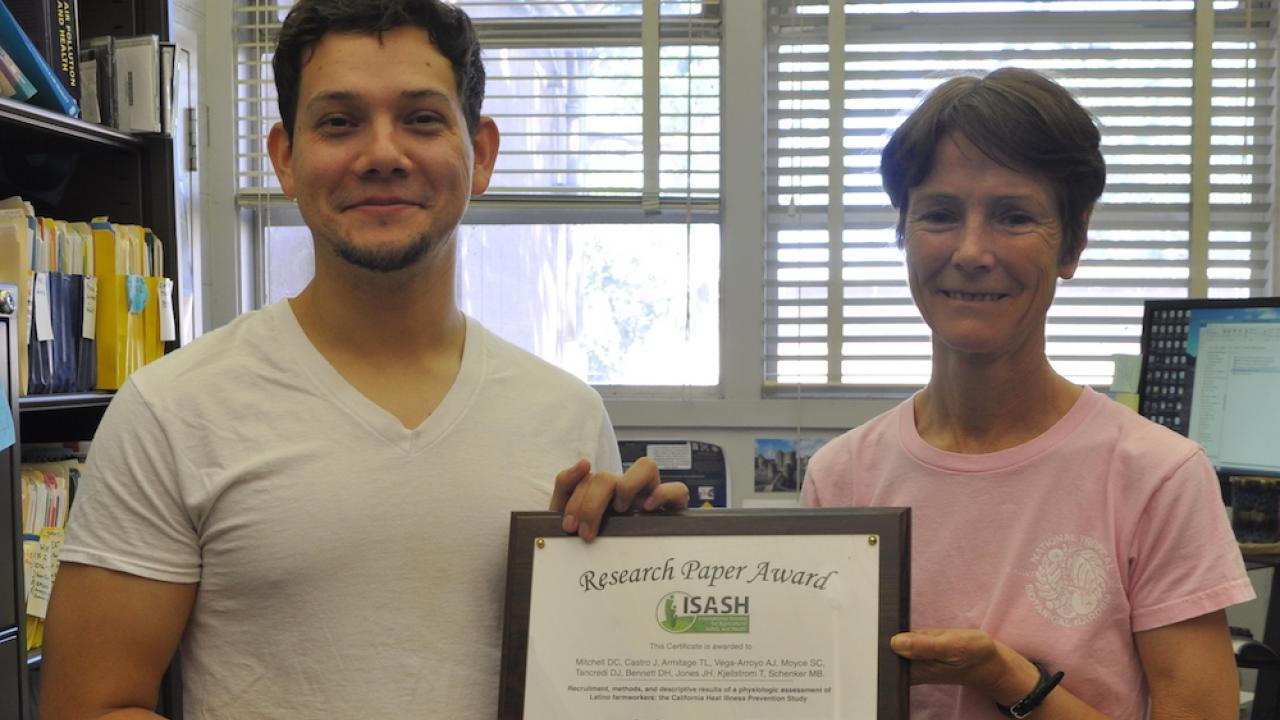 Javier Castro and Diane Mitchell hold Best Research Paper certificate