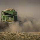 A tractor kicks up dust in a field in California