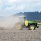 Tractor creating dust in dry field